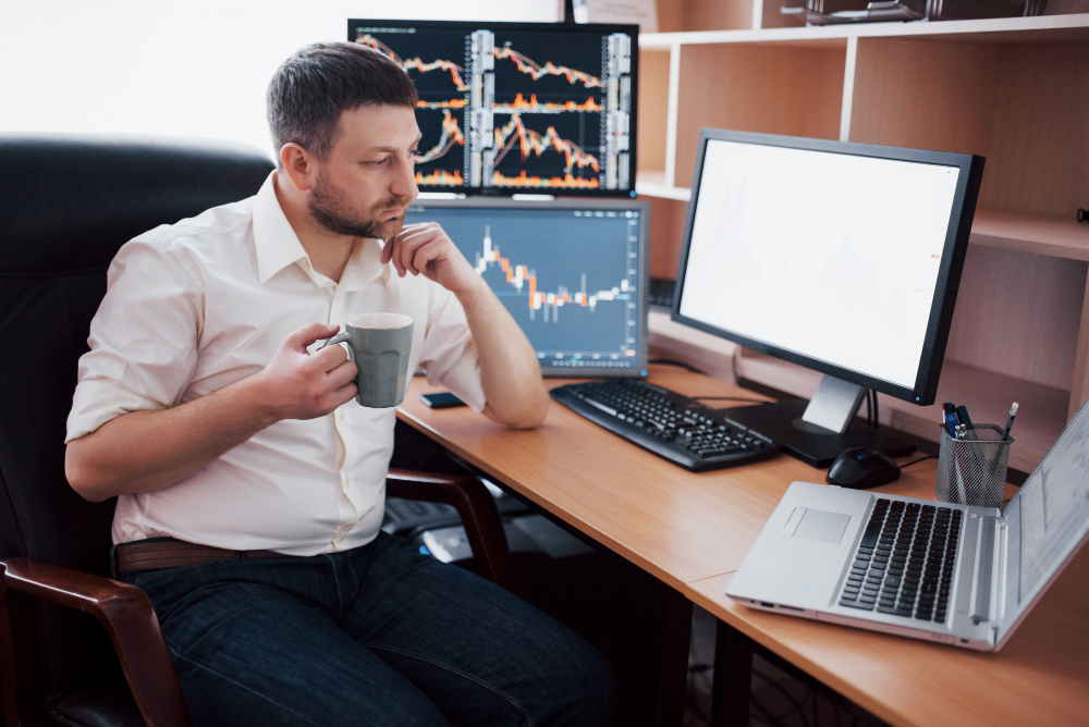 man trading with a coffee cup - Is Options Trading Worth It	