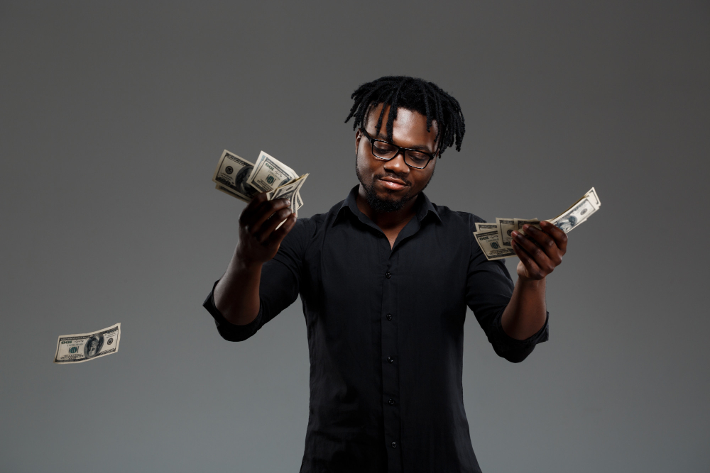 man holding dollar bills - How to Take Profits in Trading